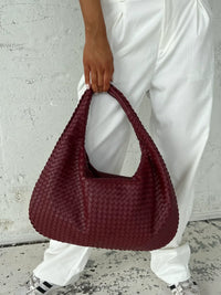Sac cabas tressé bordeaux, anses tressées, texture en tissage fin et régulier.
