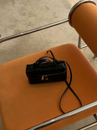 Sac à main mini boîte en cuir tressé noir avec bandoulière et fermeture zippée.