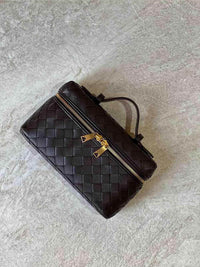 Sac à main mini boîte en cuir tressé noir, fermeture zippée, poignée et bandoulière.