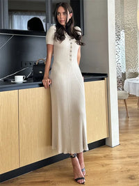 Robe longue ample blanche, taille haute, encolure V boutonnée et liseré à cordon, manches courtes
