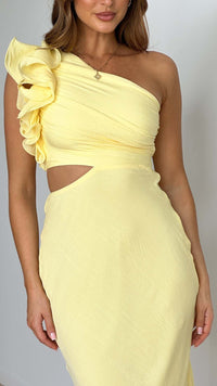 Robe longue jaune asymétrique, volant en relief sur l’épaule et découpe au buste.
