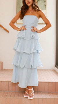 Robe longue bleue à volants superposés, bustier bandeau et jupe longue à volants en étages.