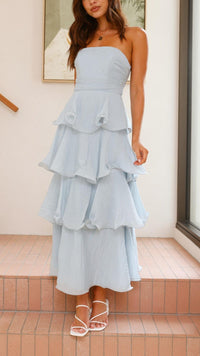 Robe longue bleue à volants superposés, taille marquée et jupe évasée à volants.