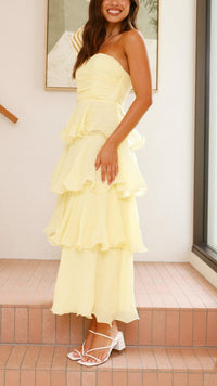 Robe longue jaune à volants superposés, bustier bandeau et jupe longue en cascade.