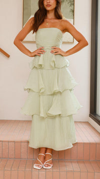 Robe longue vert clair à volants superposés, bustier bandeau et jupe à étages.