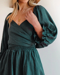 Robe midi vert foncé à col en V et manches bouffantes, taille froncée.