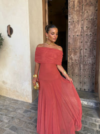 Robe longue hors de l’épaule en tissu rouge, buste drapé, jupe ample
