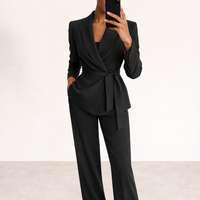 Ensemble noir blazer croisé à taille nouée et pantalon assorti.
