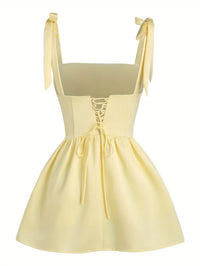 Robe midi jaune vue de dos, bretelles nouées, dos échancré, taille froncée.