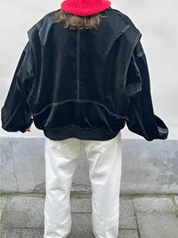 Veste en cuir oversize noire vue de dos, col montant et surpiqûres contrastées.