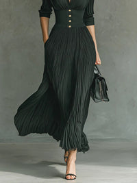 Robe longue vert foncé plissée, col à revers, boutons dorés, manches 3/4, jupe ample.
