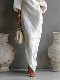 Robe longue blanche ample, une épaule avec drapé, manches 3/4.