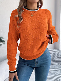 Pull en tricot orange à motifs gaufrés, col rond côtelé et poignets avec rayures blanches