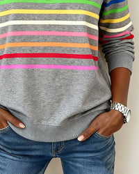 Haut sweat demi-zip gris avec rayures horizontales colorées et poches latérales.