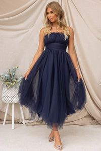 Robe longue Aera bandeau en tulle bleu nuit, taille ceinturée et jupe volumineuse.