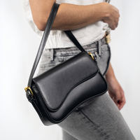 Sac porté épaule noir en cuir, rabat et surpiqûres, bandoulière ajustable.