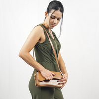 Sac porté épaule en cuir brun caramel avec rabat, fermeture zippée et surpiqûres fines.