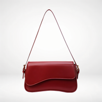 Sac porté épaule Capucine rouge bordeaux, rabat arrondi et bandoulière à attaches métalliques.