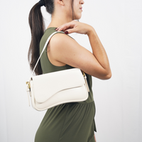 Sac porté épaule Capucine blanc avec rabat arrondi, bandoulière longue et fermoir doré.