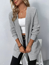 Cardigan gris clair en maille texturée, col V, poches plaquées, manches longues.