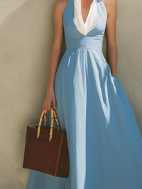 Robe longue bleu clair sans manches, encolure blanche en V, jupe plissée