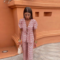 Ensemble pantalon rose à imprimé blanc : haut à lien devant, décolleté en V, manches bouffantes