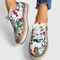 Chaussures orthopédiques à lacets blancs, tige blanche imprimée fleurs, semelle beige.