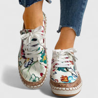 Chaussures orthopédiques à lacets blancs, tige blanche imprimée fleurs, talon et semelle beiges.