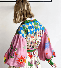 Robe longue imprimée vue dos, manches évasées, ruban vert noué et motifs ludiques.