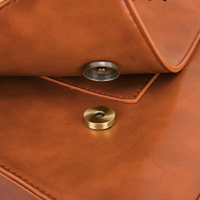 Boutons pression et finitions en cuir brun sur rabat de sac