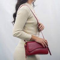 Sac porté épaule Capucine bordeaux, rabat arrondi, bandoulière avec attache dorée.