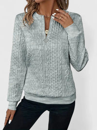 Pull à zip discret gris clair, zip et col visibles, manches longues, torsades texturées