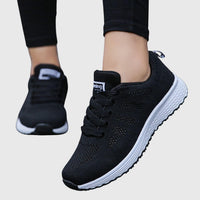 Chaussures orthopédiques noires à lacets, tige textile ajourée, semelle blanche crantée.