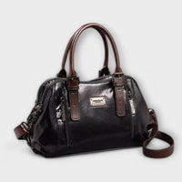 Sac à bandoulière vintage en cuir noir, anses, fermeture zippée et bandoulière.