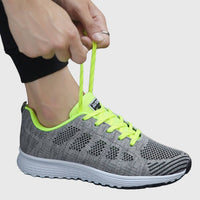 Chaussures orthopédiques vert fluo à lacets, tige textile ajourée, semelle blanche crantée.