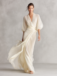 Robe longue ivoire transparente, drapés fluides, manches chauve-souris et ceinture nouée.