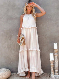 Robe longue dos nu en tissu clair, volants superposés et surplis de bas de robe