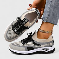 Baskets orthopédiques blanches et noires à maille, lacets noirs, semelle blanche