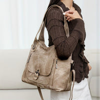 Sac à main vintage beige avec bandoulière, poche avant à rabat et fermoir central.