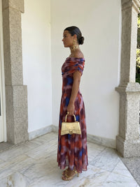 Robe longue bardot imprimée abstraite rouge et bleu, manches épaules tombantes.