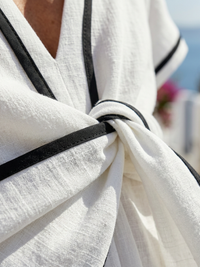 Détail tissu de robe : nœud et passepoil noir sur voile blanc