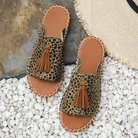 Sandales orthopédiques à imprimé léopard vert, brides et pompon en cuir brun.