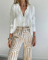 Ensemble deux pièces : blouse blanche, pantalon beige à motifs, ceinture assortie