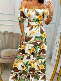 Robe longue blanche à épaules dénudées, imprimé feuilles et fleurs, volants bas.