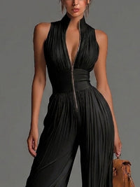 Combinaison en mousseline noire à col halter, zip devant, corsage froncé, plis verticaux.