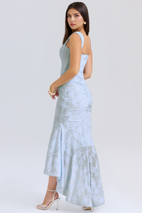 Robe longue bleutée à bretelles, dos partiellement visible, silhouette cintrée, fente