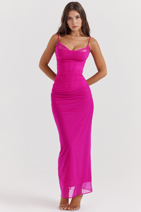 Robe longue rose vif en dentelle, bretelles fines, coupe près du corps, ourlet fluide.