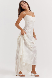 Robe longue blanc cassé à fines bretelles, motif floral, taille froncée, effet superposition sur l’ourlet.