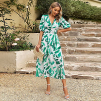 Robe midi à col en V blanche à imprimé vert, manches bouffantes, taille froncée.