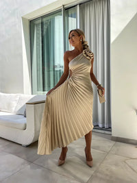 Robe mi-longue une épaule beige plissée avec rosette fleur sur l’épaule, manches asym.